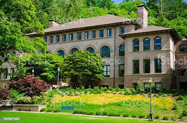 Old Main, a brick building, surrounded by lush greenery.